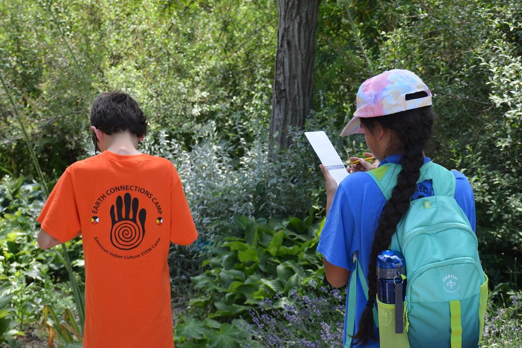 Two children on a trail reading a field guide