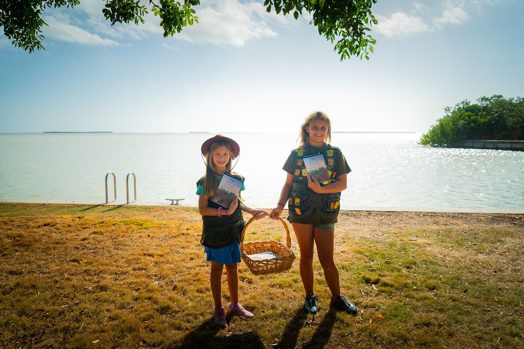 Two girls holding completed activity booklets