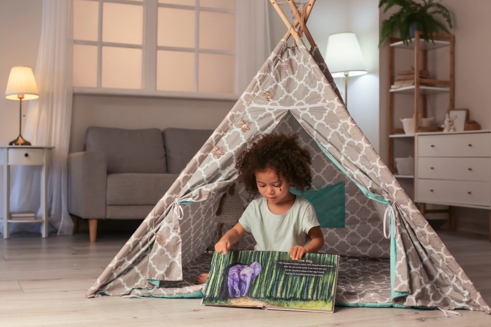 A child reading inside a play tent